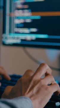 Vertical Screen : Closeup young adult Asia male freelance typing write prompt AI bot app program nomad, video game, terminal with coding language, big data center on desktop computer in night office.