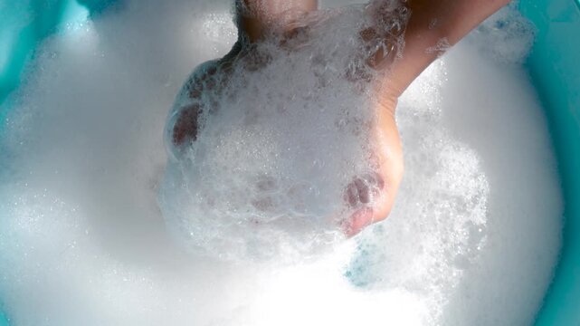 Hands Holding Soap Bubbles in Clean Water, Close-up, Wash hands hygiene, cleanliness, handwashing routine, and disease prevention through proper sanitation