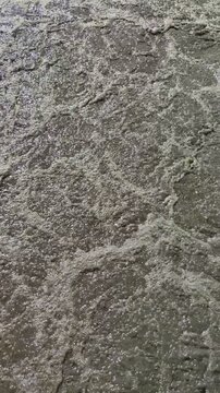 Close-up of the active aeration tank in a wastewater treatment plant. High-angle view of bubbling brown sludge and biological processes used in industrial water purification and treatment.