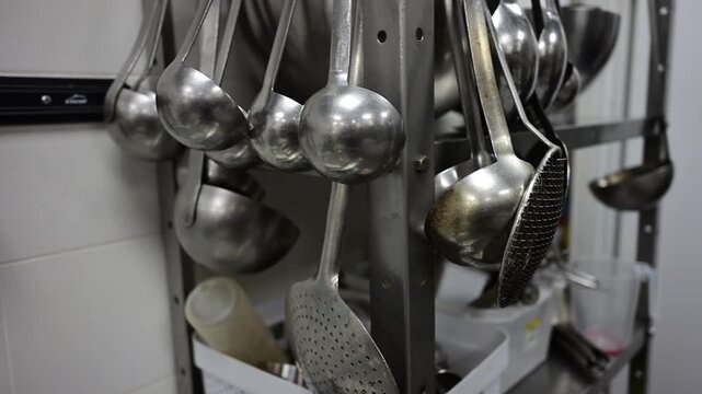 Stainless steel utensils hanging in a commercial kitchen