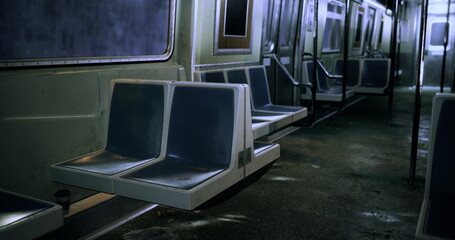 A deserted subway train interior features vacant seats and dim lighting, creating a quiet atmosphere. The floor shows signs of wear, emphasizing neglect and solitude in public transport. © icetray
