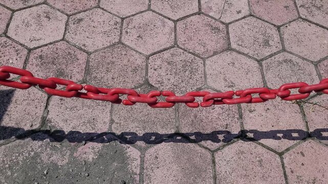 red chain link fence on the construction site with paving block floor