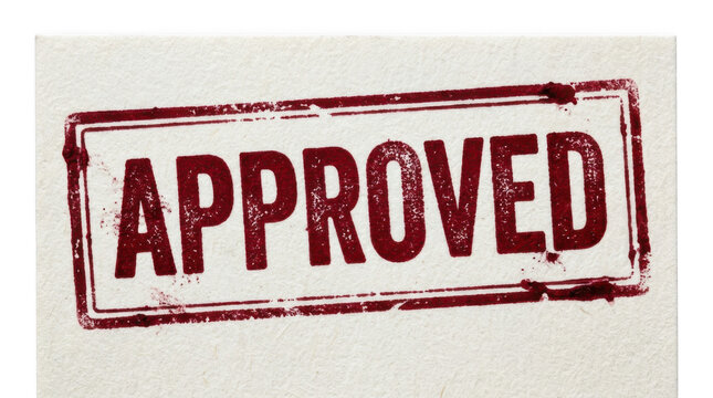 A distinct red rubber stamp impression of the word APPROVED enclosed in a rectangular frame is centered on textured off white paper Its distressed gru