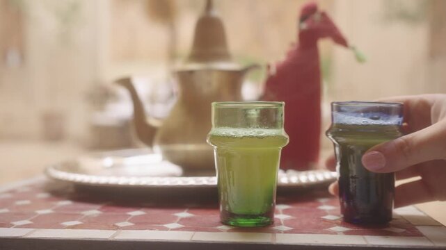 Person pouring hot Moroccan tea inside traditional riad in Marrakesh