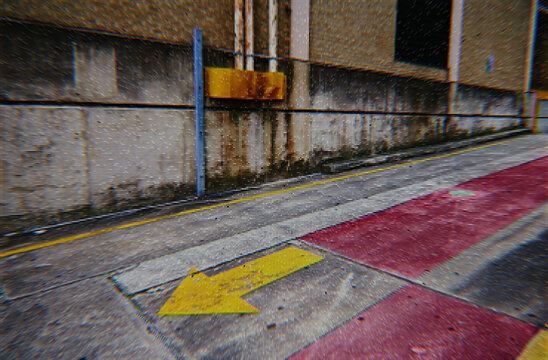 Urban street with yellow directional arrow and digital glitch effect