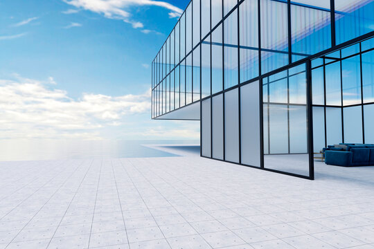 Modern glass building with large windows and terrace by the ocean