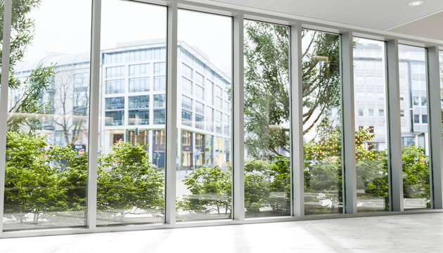 Modern hotel lobby with large windows plants and urban city view