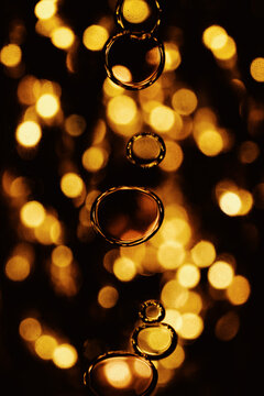 Abstract bubbles with golden bokeh in colorful liquid