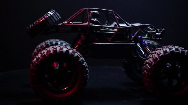 off-road toy cars turn with big tires art creative in water splashes 360 degree rotation on dark background with red backlight