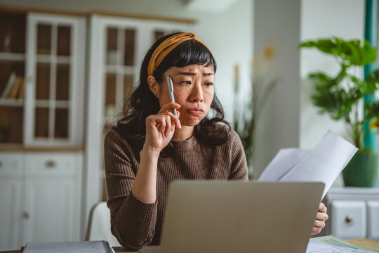 Woman experiencing frustration compiling financial documents and calculations