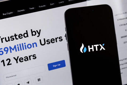 HTX (Huobi) mobile logo app on a screen smartphone iPhone with notebook. HTX (Huobi) - one of the largest cryptocurrency exchange on the market. Batumi, Georgia - February 19, 2026