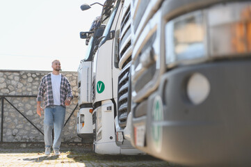 Fototapeta premium Young man walking past semi trucks in parking lot
