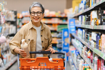 Mature woman smiling buying products in supermarket © Serhii