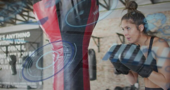 Female boxer stepping and throwing gloved strikes at red bag for drills, blue HUD marking form