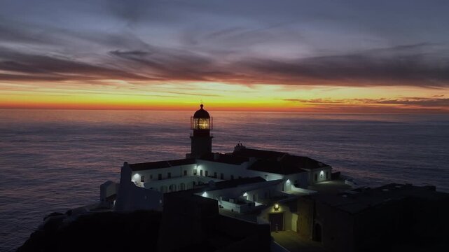 Coastal lighthouse at sunset on dramatic cliffs in Europe