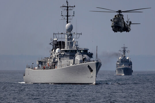 A group of patrol warships accompanied by a helicopter are carrying out a peacekeeping mission in the mediterranean sea. Battleships in action.	