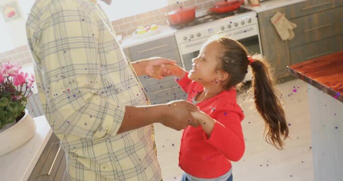 Dad grabbing girl's hand, guiding spins in kitchen while sparkles around them, building family bond