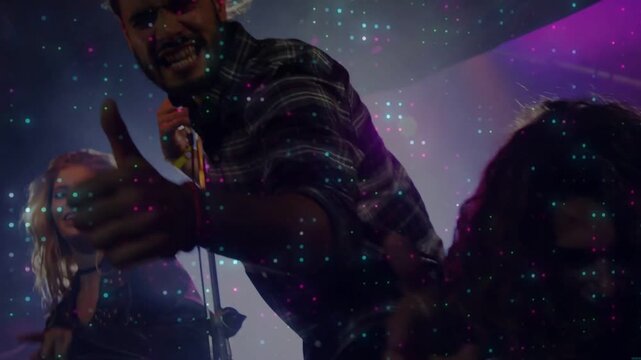 Frontman grabbing mic, leaning, pointing at crowd, driving music energy, dots overlaying performers