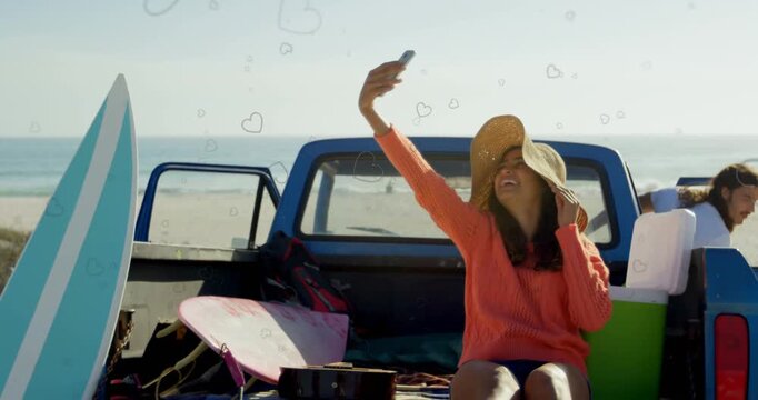 Woman lifting phone, taking selfies in truck for social media, hearts appearing, man approaching