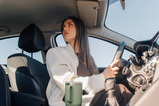 Woman driving car reversing looking back for safety