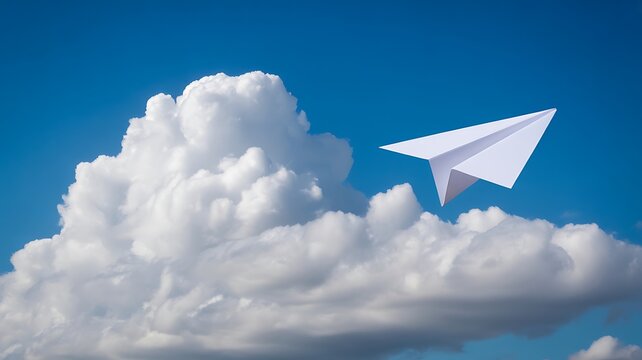 Paper airplane flying on white clouds against blue sky