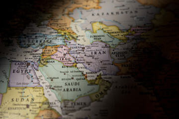 Dramatically lit world map focusing on Iran and the Middle East region, highlighting geopolitical hotspots and international borders in shadow © Rokas