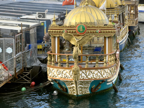 View of ornate boats bob gently, their golden domes gleaming, reflecting in the water, Istanbul, Istanbul, Turkey.