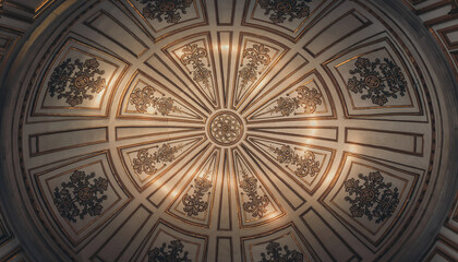 Fototapeta premium Ornate ceiling with intricate floral and geometric patterns in gold and dark tones.