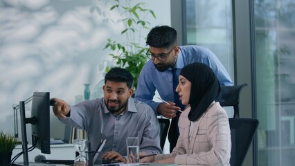 Fototapeta premium Islamic Arabian Muslim business team colleagues arguing screaming in office misunderstanding discuss online computer work problem quarrel woman in hijab upset two businessmen angry talking bad result