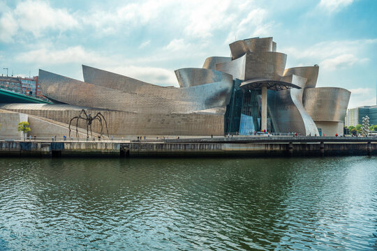 Bilbao, Spain - September 18, 2022: Guggenheim Museum Bilbao in Spain with curved titanium forms beside the Nervion River and riverside promenade, Bilbo, Basque country. Contemporary architecture