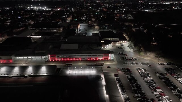 High Aerial l Exterior View Of Busy High School At Night With Bright Lights