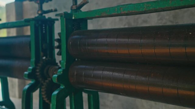 Industrial rolling mill machine used for pressing and shaping materials through rotating cylinders. Used to flatten metal sheets, rubber, or plastic