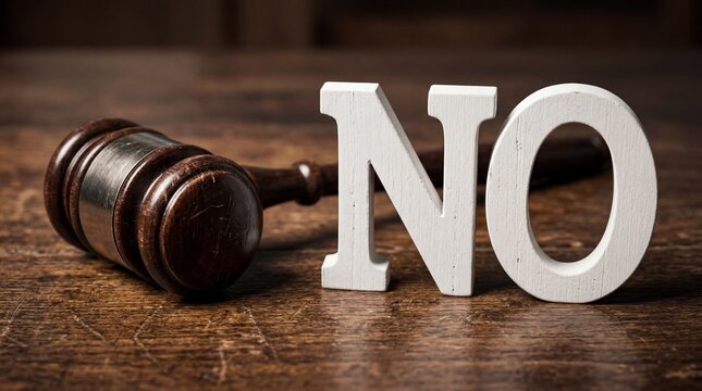 Gavel and the word NO on a wooden table representing a legal decision.