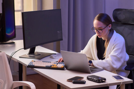 Female leader at desk. Businesswoman focusing while jotting notes in home office. Female professional concentrating deeply on her work during late-night office hours