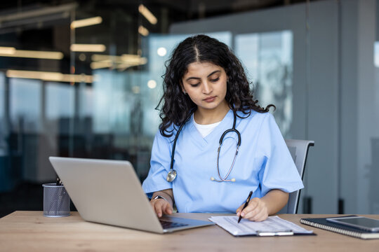 Female healthcare worker researching medical data on laptop