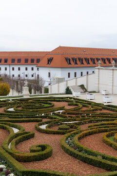 View of manicured gardens and a grand building with a red-tiled roof on a muted day create a striking contrast of textures and colors, Bratislava, Bratislava Region, Slovakia.