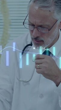 Vertical video: Candlestick chart overlay sliding, medical doctor writing and adjusting stethoscope