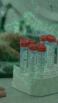 Vertical video: Arm entering lower left, grasping and lifting tube for testing with green overlay