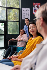 Naklejka premium Nurse helping woman with physical injury to attend rehabilitation appointment in hospital waiting area, Senior doctor talking with asian patient explaining disease diagnosis. Medicine concept
