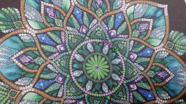 Female hands carefully stitching beads on patterned fabric. Concept of slow living, mindfulness, relaxing hobby, and detailed handcraft work with focus on texture and rhythm.