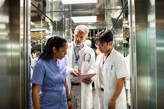 Doctors and nurse discussing patient in hospital elevator