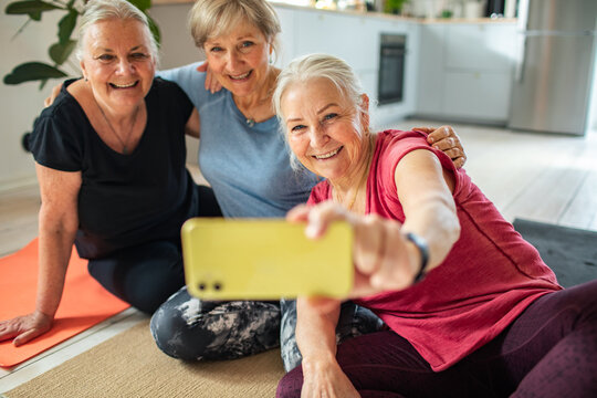 Three senior women taking yoga selfie at home