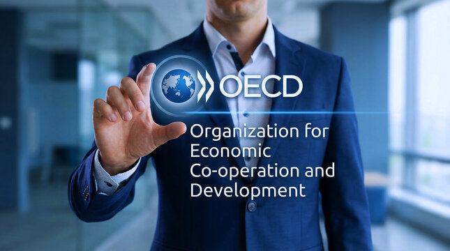 A businessman in a blue suit interacts with a digital interface displaying the OECD logo in a modern office setting.