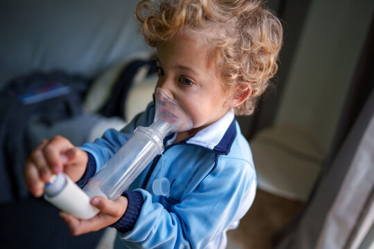 Toddler receiving breathing treatment for respiratory health using medical inhaler equipment