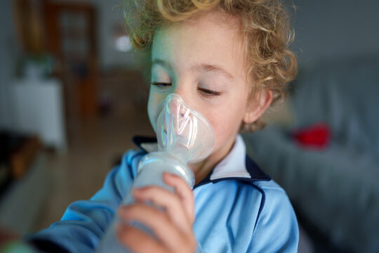 Young child receiving respiratory treatment with nebulizer mask, focusing on breathing for health improvement