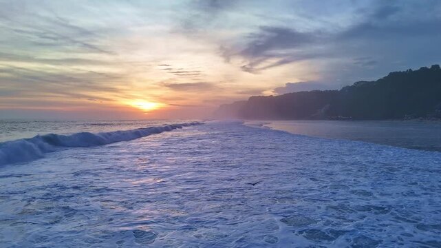 Aerial drone flight over ocean and cliffs at sunset, cinematic seascape, sunset over ocean and rocky coastline