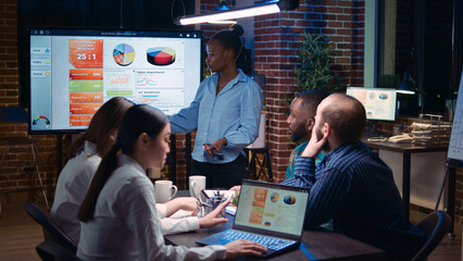 Business analytics meeting, african american project manager showing corporate presentation, team discussing statistics, planning sales strategy. Coworkers watching diagrams at digital board © DC Studio