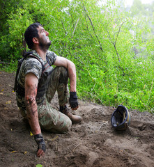 Naklejka premium Young soldier sitting on the ground