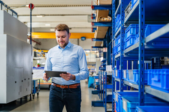 Man using tablet in production hall warehouse for business organization