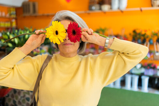 Customer posing playfully with flowers in floral shop